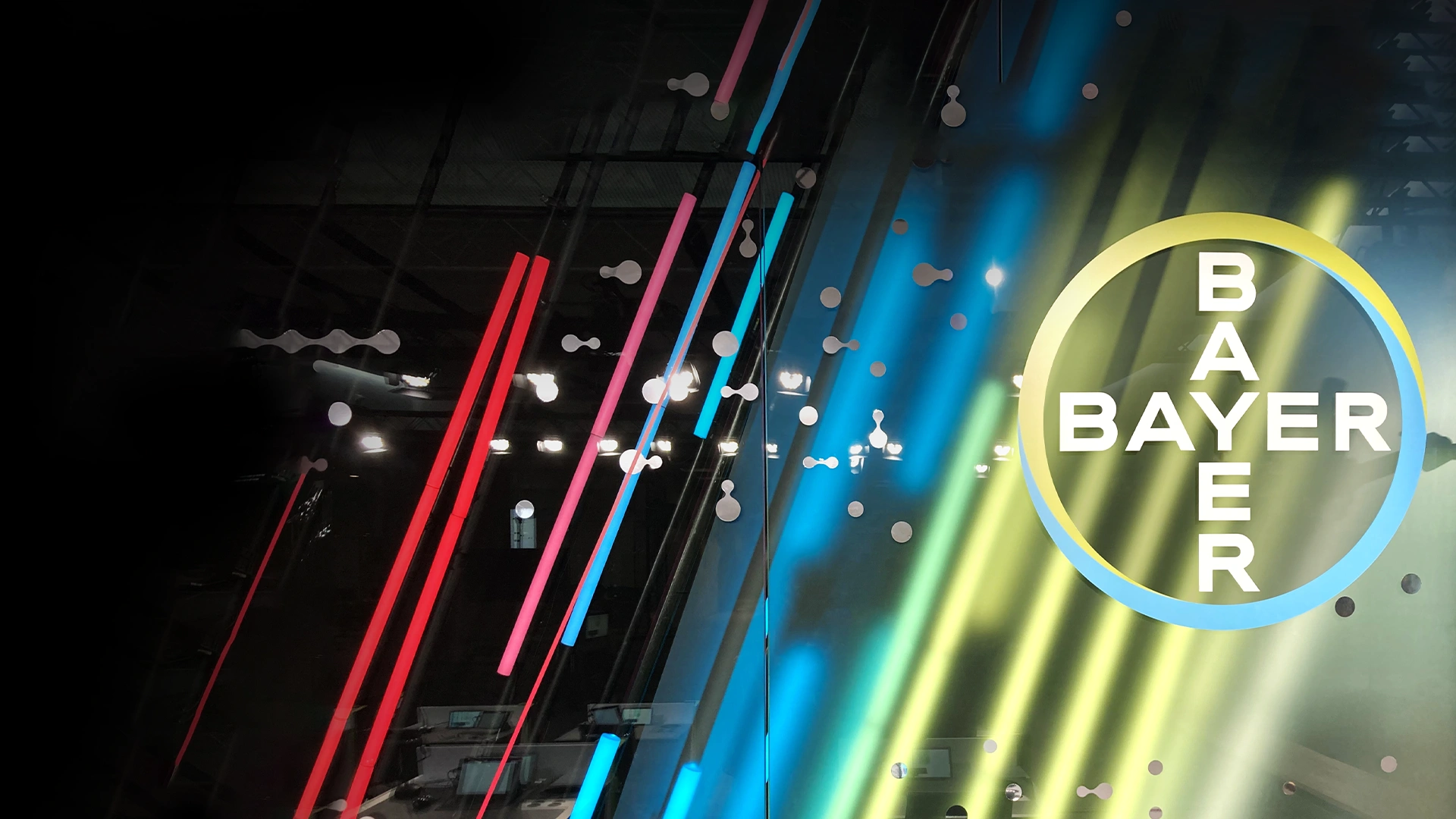 Bayer-Logo vor buntem Hintergrund.